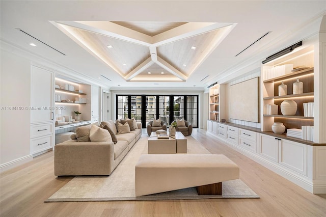 living room featuring crown molding, built in features, and light hardwood / wood-style flooring