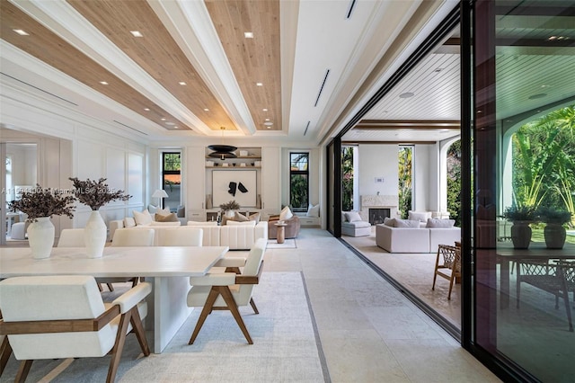 dining room with a fireplace, a decorative wall, beamed ceiling, and recessed lighting