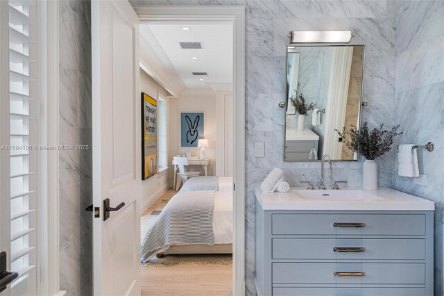 bedroom featuring french doors, a raised ceiling, light hardwood / wood-style floors, and multiple windows