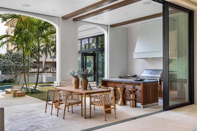 bedroom featuring multiple windows, access to exterior, and a raised ceiling