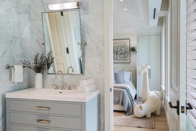 bathroom featuring vanity, wood-type flooring, tile walls, and backsplash