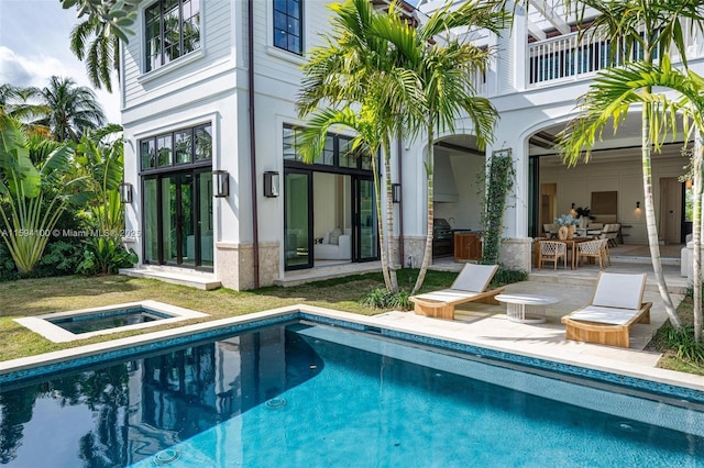 exterior space featuring an in ground hot tub, outdoor dining space, and a patio area