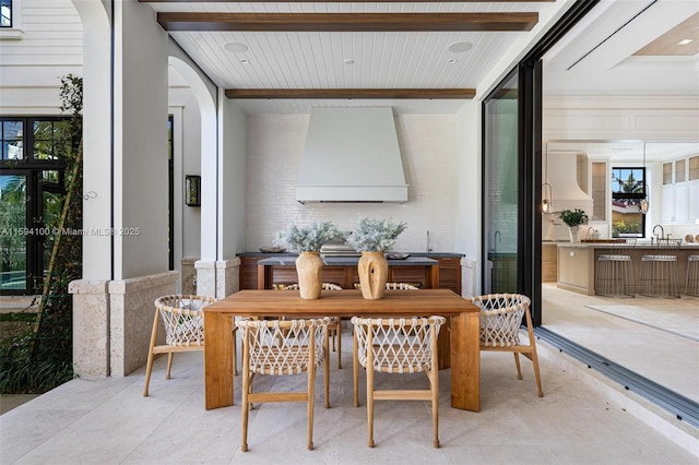 dining area featuring beamed ceiling and sink