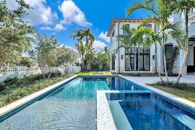 view of pool featuring an in ground hot tub and a patio