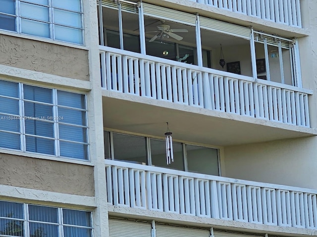 view of side of home featuring ceiling fan and a balcony