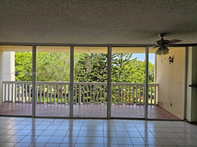 unfurnished sunroom with ceiling fan