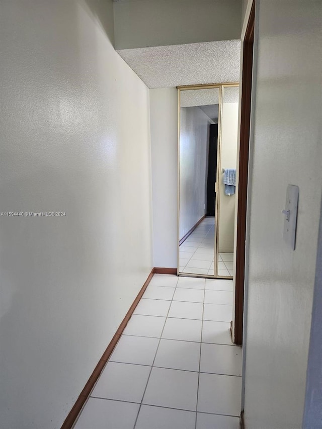 hallway with light tile patterned flooring and a textured ceiling