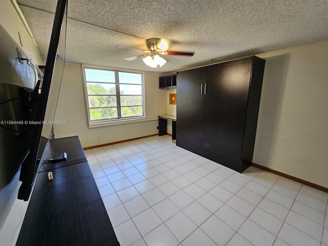 unfurnished bedroom with ceiling fan, a textured ceiling, and light tile patterned floors