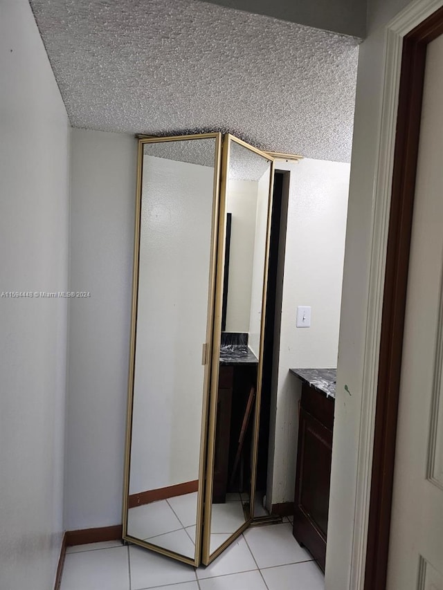 bathroom with a textured ceiling, tile patterned floors, and vanity