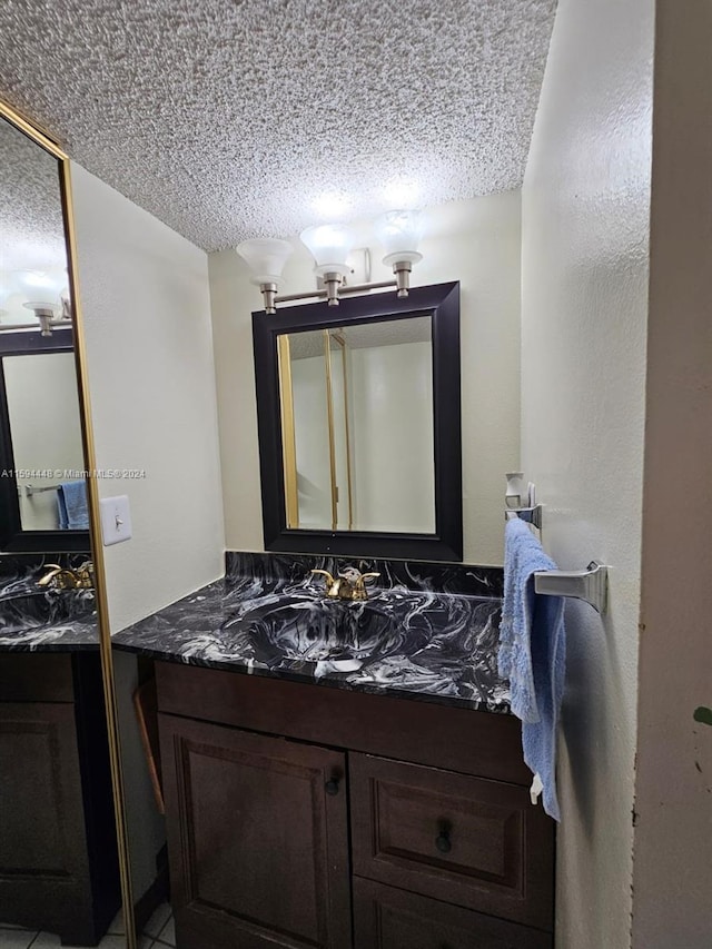 bathroom featuring a textured ceiling and vanity