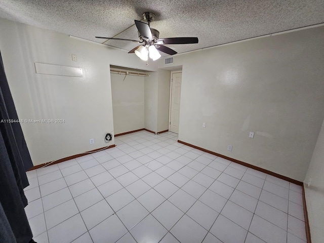 tiled spare room with ceiling fan and a textured ceiling