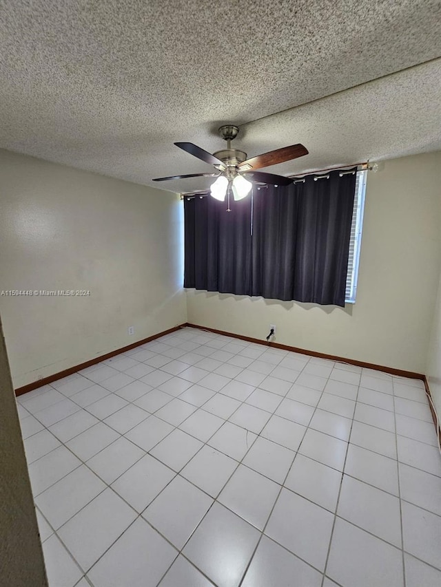 tiled empty room featuring a textured ceiling and ceiling fan