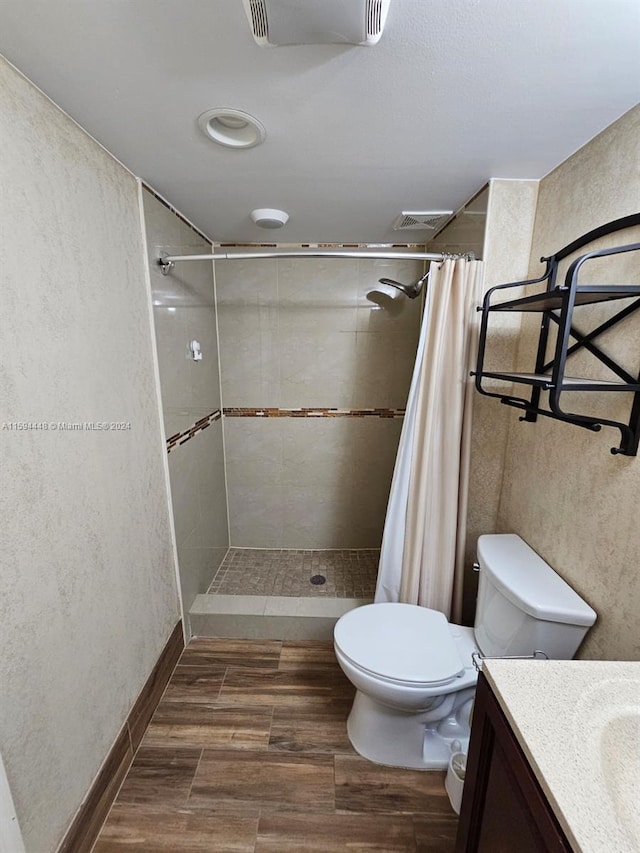 bathroom featuring a shower with shower curtain, vanity, toilet, and hardwood / wood-style floors