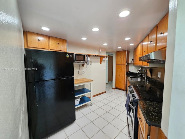 kitchen featuring stainless steel microwave, freestanding refrigerator, range with electric stovetop, under cabinet range hood, and a sink