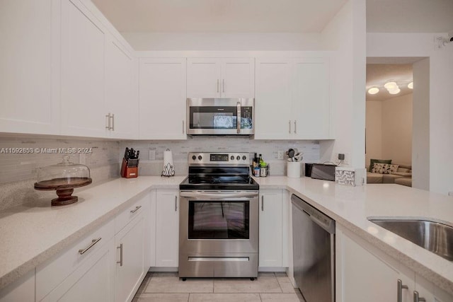 kitchen with white cabinets, tasteful backsplash, and appliances with stainless steel finishes