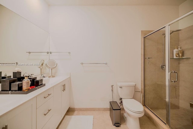 bathroom featuring a shower with door, tile flooring, vanity, and toilet