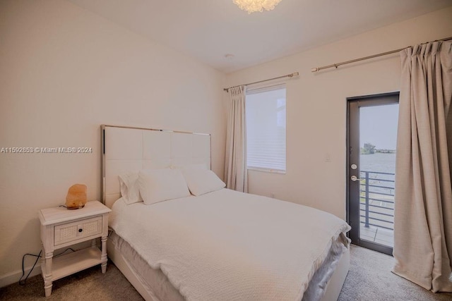 carpeted bedroom featuring a water view and access to exterior