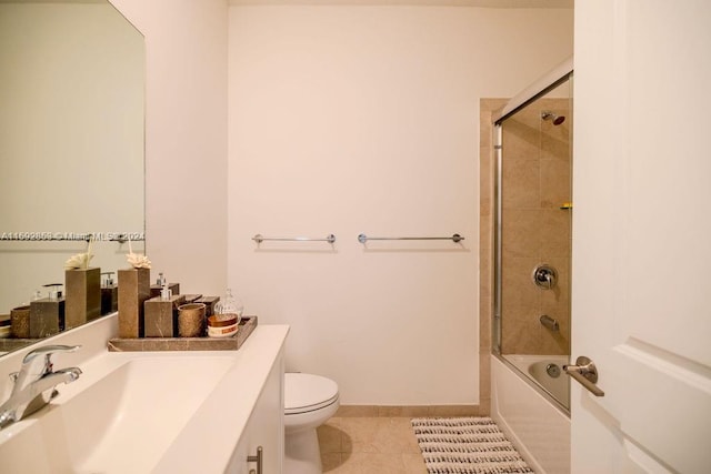 full bathroom with tile floors, bath / shower combo with glass door, vanity, and toilet