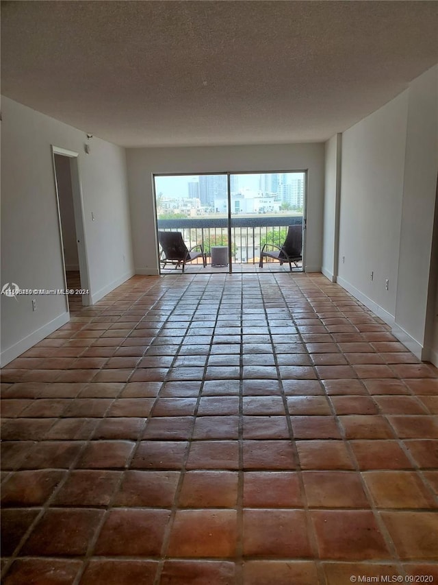 unfurnished room featuring tile flooring and a textured ceiling