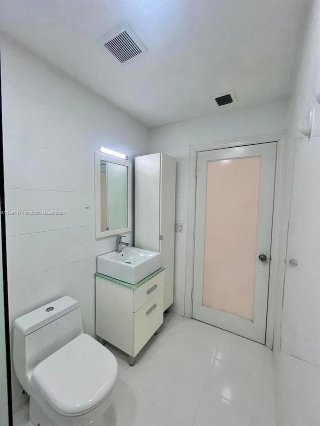 bathroom featuring tile patterned flooring, toilet, and vanity