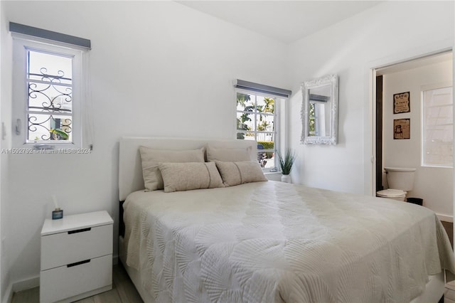 bedroom featuring wood-type flooring and connected bathroom