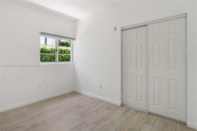 unfurnished bedroom with light hardwood / wood-style floors and a closet