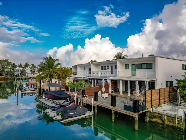 view of dock with a balcony and a water view