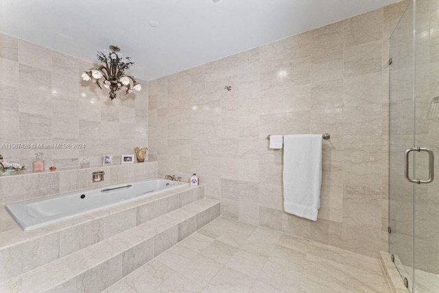 bathroom with tile flooring, tile walls, an inviting chandelier, and plus walk in shower