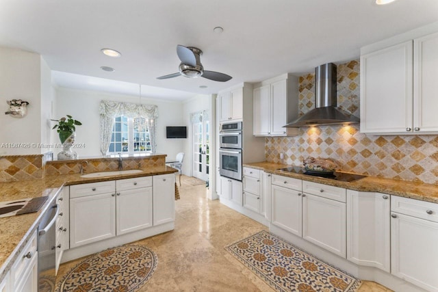 kitchen featuring white cabinetry, sink, backsplash, and wall chimney exhaust hood