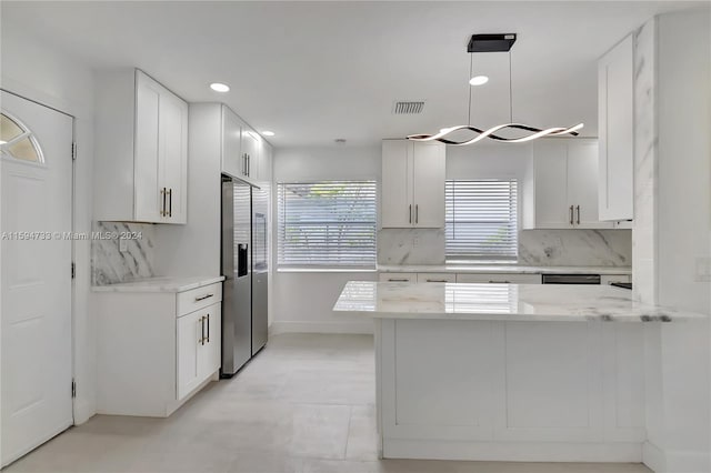 kitchen featuring kitchen peninsula, white cabinets, and decorative light fixtures