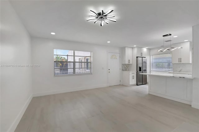 unfurnished living room with ceiling fan