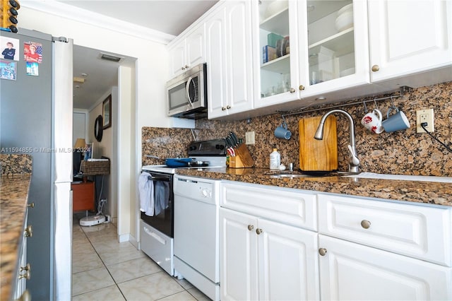 kitchen featuring appliances with stainless steel finishes, crown molding, sink, dark stone countertops, and white cabinets