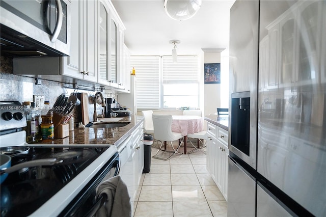 kitchen with backsplash, stainless steel appliances, white cabinetry, and sink