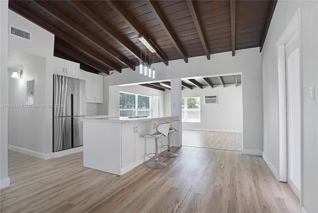 kitchen with white cabinetry, light wood-type flooring, wood ceiling, beamed ceiling, and stainless steel fridge