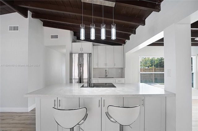 kitchen with white cabinetry, backsplash, wood ceiling, stainless steel fridge, and lofted ceiling with beams