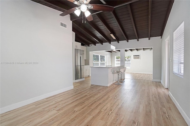 unfurnished living room with wood ceiling, light wood-type flooring, ceiling fan, and beam ceiling