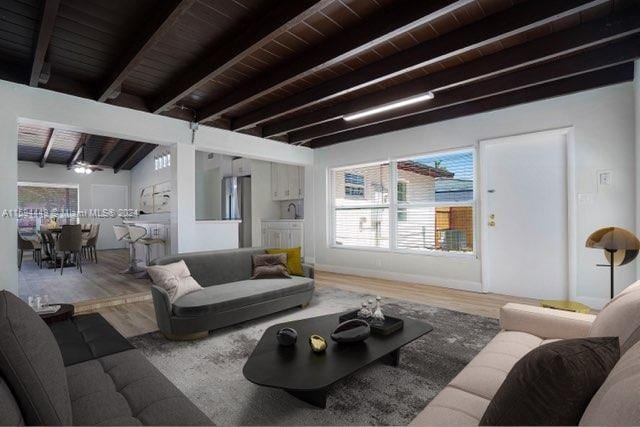 living room with vaulted ceiling with beams, hardwood / wood-style floors, and wooden ceiling