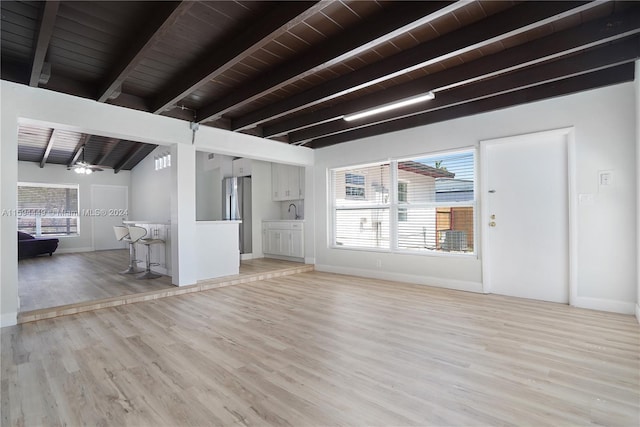 unfurnished living room featuring sink, wood ceiling, ceiling fan, lofted ceiling with beams, and light wood-type flooring