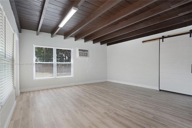 interior space with beam ceiling, light hardwood / wood-style flooring, a barn door, a wall mounted AC, and wooden ceiling