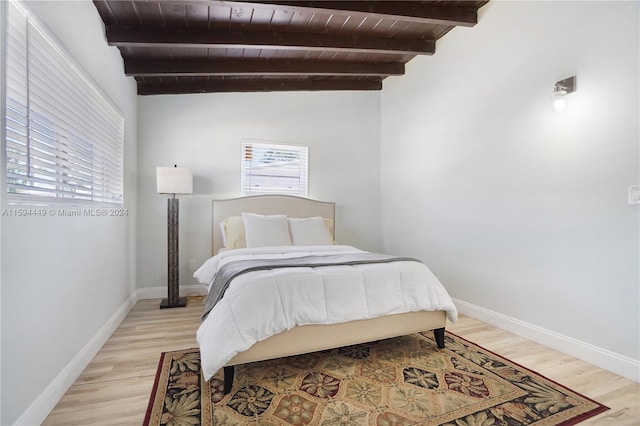 bedroom featuring wood ceiling, light hardwood / wood-style floors, and multiple windows