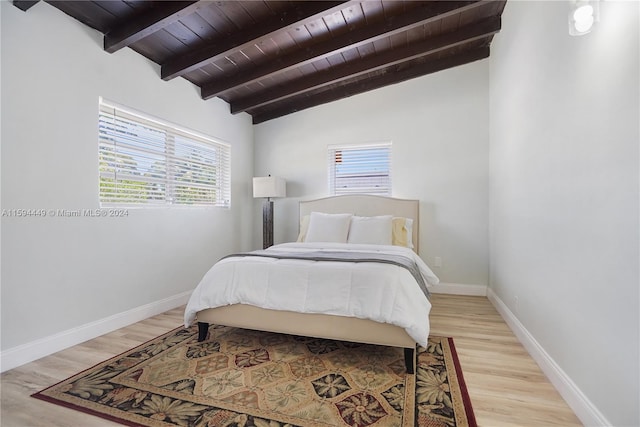 bedroom featuring hardwood / wood-style flooring, vaulted ceiling with beams, and wooden ceiling