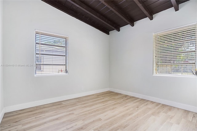 empty room featuring lofted ceiling with beams, light hardwood / wood-style floors, and wooden ceiling