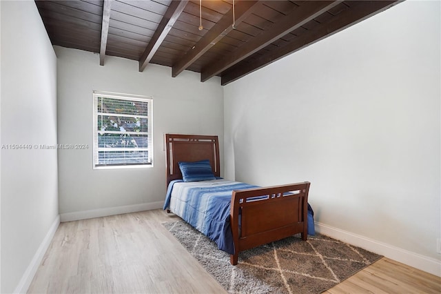 bedroom featuring beamed ceiling, wooden ceiling, and hardwood / wood-style flooring