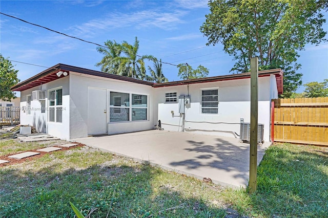 back of house with a patio, central air condition unit, and a yard