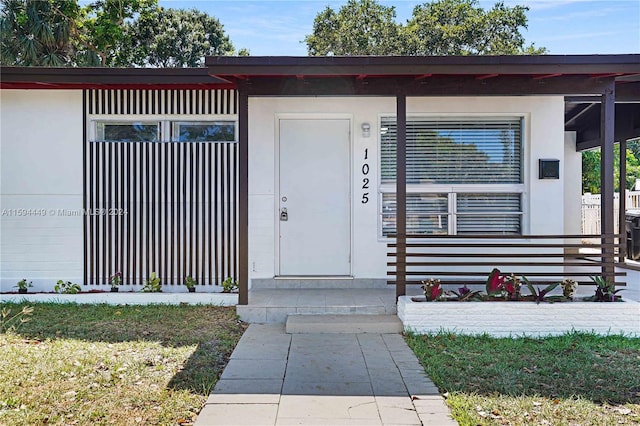 entrance to property with a lawn