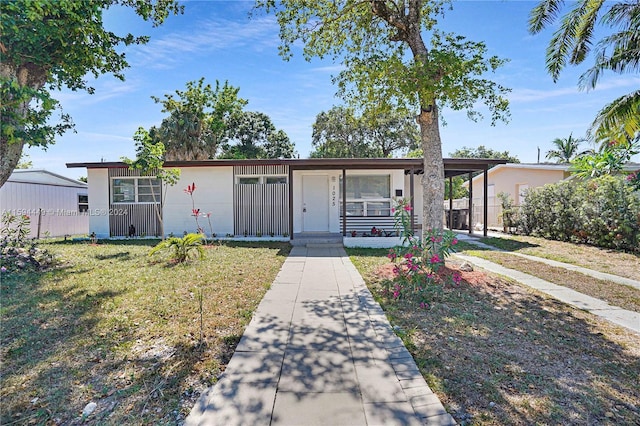 view of front of house featuring a carport and a front yard