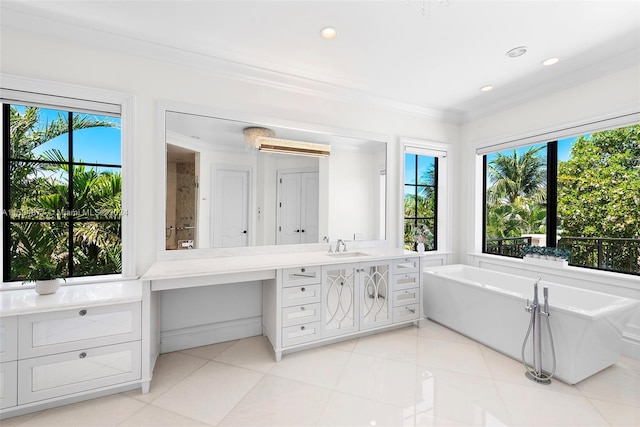 bathroom with tile patterned floors, vanity, a bathtub, and crown molding