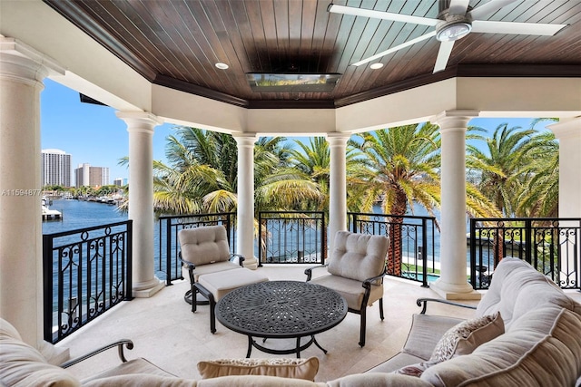 view of patio / terrace with an outdoor living space, a water view, ceiling fan, and a balcony