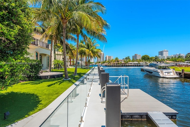 view of dock featuring a lawn and a water view