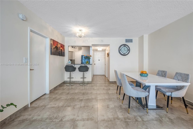 dining area with light tile patterned floors and a textured ceiling